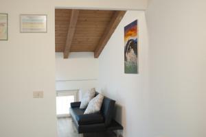 una sala de estar con una silla y una pintura en la pared en Il Borgo appartamento Luca en Parma