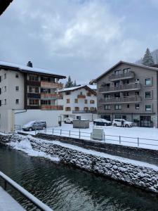 un grupo de edificios junto a una masa de agua en TOP LOCATION - Klosters center - 130m distance to ski lift Parsenn Gotschnabahn and railway station Klosters Platz - direct connection to Davos, en Klosters