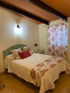 um quarto com uma cama grande e uma janela em Buhardilla Rústica Mirando a Santa Catalina em Jerez de los Caballeros