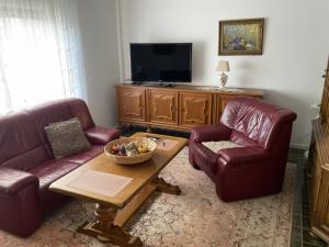 a living room with two couches and a television at Fewo An der Mühlenbachaue in Nettetal