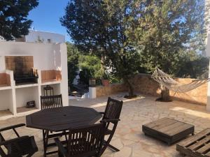 a patio with a table and chairs and a hammock at CASA ANA in Sant Josep de sa Talaia
