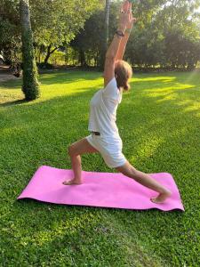 a woman doing a yoga pose on a pink yoga mat at casa-quinta cerca de corrientes y santa ana in Corrientes