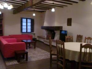 a living room with a red couch and a table at La Posada de Pesquera in Pesquera de Duero