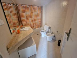 uma casa de banho com um WC, um lavatório e um espelho. em Vera playa laguna beach em Vera