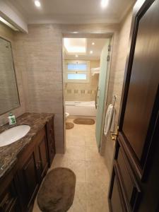 a bathroom with a sink and a toilet and a tub at Luxury Apartment In Massaken Sheraton near Cairo Int'l Airport in Cairo