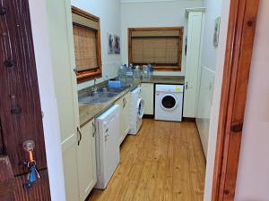 een keuken met een wastafel en een wasmachine bij Eagles Call in Port Edward