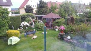 a garden with a bench and a dog laying in the grass at Gemütliche 3 Zimmer-Ferienwohnung in Langelsheim