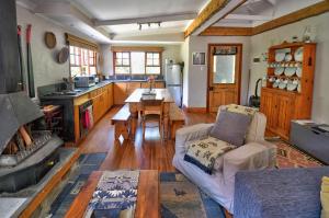 een woonkamer met een tafel en een keuken bij Maple Grove in Hogsback