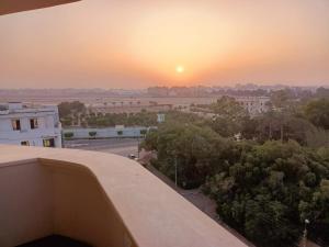 een zonsondergang vanaf het dak van een gebouw met bomen bij Luxury Apartment In Massaken Sheraton near Cairo Int'l Airport in Caïro