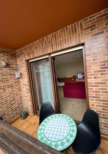 Habitación con mesa, sillas y pared de ladrillo. en Apartamento en Ajo, Cantabria en Ajo