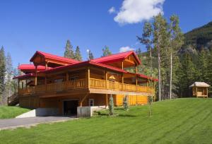 uma grande casa de madeira com um telhado vermelho em Jasper East Cabins em Jasper