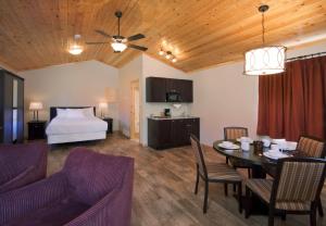 a living room with a dining table and a bed at Jasper East Cabins in Jasper