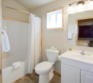 a white bathroom with a toilet and a sink at Jasper East Cabins in Jasper