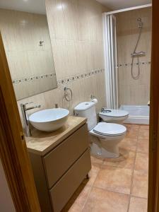 ein Badezimmer mit einem Waschbecken, einem WC und einer Badewanne in der Unterkunft Apartamento Rural Casa Bergua en Arguis in Arguis