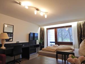 Schlafzimmer mit einem Bett, einem Schreibtisch und einem Fenster in der Unterkunft FREE Apartment - Am Brühlbach in Bad Urach