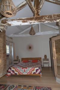 a bedroom with a bed in a room with wooden ceilings at LA CAVERIE DE PEYROUX A ORTHEVIELLE (40300) in Orthevielle