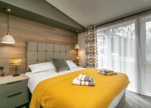 Un dormitorio con una gran cama amarilla con toallas. en Blaithwaite Country House Estate, en Wigton