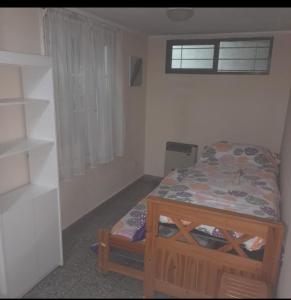 Habitación pequeña con cama y ventana en La Perla 3 amb en Mar del Plata