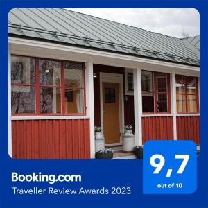 a house with a red door with the text travelling review awards on it at B&B Lapväärtti in Lapväärtti