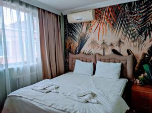 イスタンブールにあるSeyri Istanbul Hotelのベッドルーム1室(白いシーツとヤシの木の壁画付)