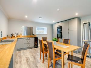 a kitchen and dining room with a wooden table and chairs at Little Elrick-uk42940 in Newmacher