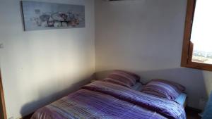 - une chambre dotée d'un lit avec des oreillers et une photo sur le mur dans l'établissement Chaleureuse petite maison avec jardin, à Gagnac-sur-Cère