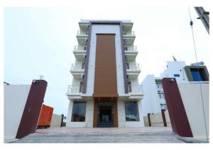 索姆纳特Hotel Scintilla的前面有一扇门的高大的白色建筑