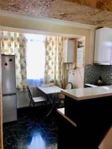 eine Küche mit einem Kühlschrank und einem Tisch in der Unterkunft Homee in Tbilisi City