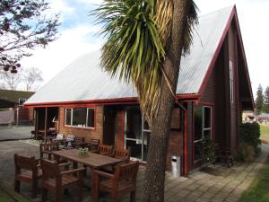 a cabin with a table and chairs and a palm tree at Hanmer Backpackers in Hanmer Springs