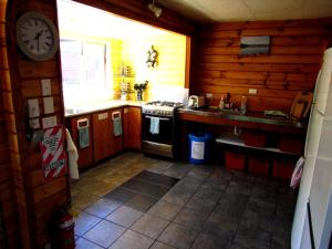 a kitchen with a stove and a clock on the wall at Hanmer Backpackers in Hanmer Springs