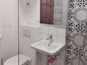 een witte badkamer met een wastafel en een toilet bij Nice Home in Maccagno con Pino e Veddasca with garden in Maccagno Inferiore
