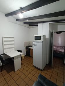 una pequeña cocina con nevera y microondas en Carlos Paz Centric Apartaments en Villa Carlos Paz