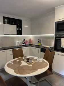 a kitchen with a table and chairs in a kitchen at Appartement Wonder in Couvet