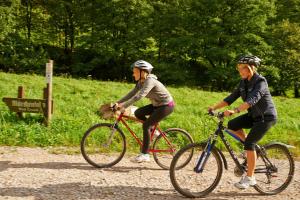 two women riding bikes down a dirt road at FeWo mit Terrasse für 4-5 Personen mit Schwimmbad + Sauna in Bad Grund