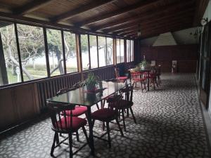 a row of tables and chairs in a room with windows at Vila Balkan in Kikinda