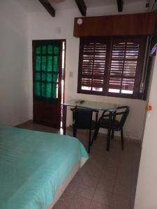 1 dormitorio con cama, mesa y escritorio en Carlos Paz Centric Apartaments en Villa Carlos Paz