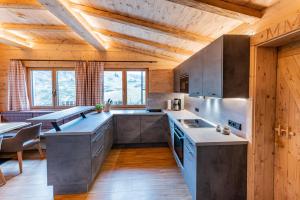 a kitchen with stainless steel appliances and a wooden ceiling at Pfefferkornhütte in Warth am Arlberg