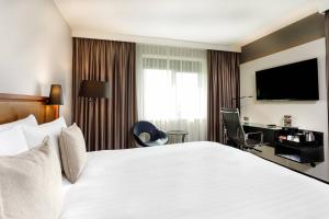 a hotel room with a large bed and a desk at Courtyard by Marriott Amsterdam Airport in Hoofddorp