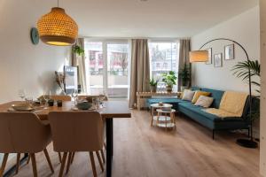 ein Wohnzimmer mit einem blauen Sofa und einem Tisch in der Unterkunft Green-Art-Living: NEW BOHO Style Central für 2 in Kempten