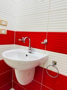 a white sink in a red and white bathroom at 91 الميرلاند الدور 7 in Cairo