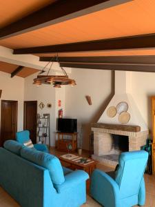 a living room with two blue chairs and a fireplace at Buhardilla Rústica Mirando a Santa Catalina in Jerez de los Caballeros
