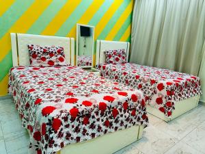 two beds with red and white covers in a bedroom at 91 الميرلاند الدور 7 in Cairo