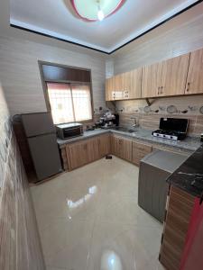 a large kitchen with wooden cabinets and a window at House tour dakhla in Dakhla