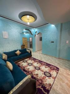 a living room with a blue couch and a rug at House tour dakhla in Dakhla