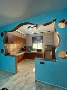 a large kitchen with a blue wall at House tour dakhla in Dakhla