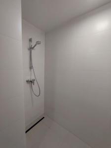 y baño con ducha en una pared blanca. en Pokoje Kraków Tyniec, en Cracovia