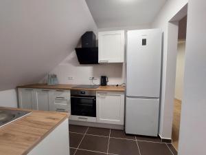 a kitchen with white cabinets and a refrigerator at Pokoje Kraków Tyniec in Krakow