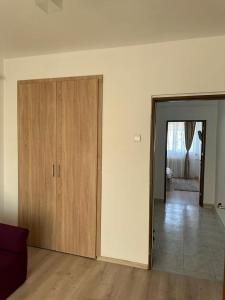 an empty living room with wooden cabinets and a door at Velovan Apartment in Craiova