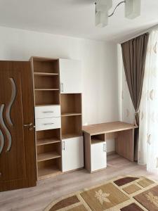 Habitación con armario con estanterías y puerta en Velovan Apartment, en Craiova
