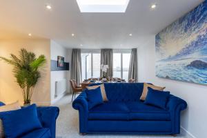 a blue couch in a living room with a table at Regent Grand Penthouse in Brighton & Hove